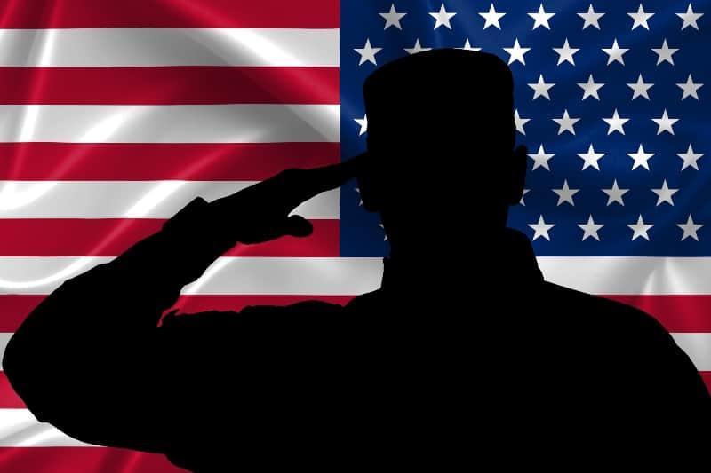 silhouette of soldier saluting with U.S. flag in background