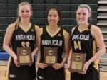 3名微笑的女子篮球运动员拿着奖项