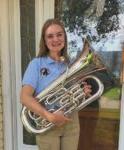 Female college student standing & holding euphonium